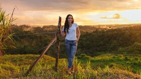 Catalina Vélez stoji na sončnem polju ob sončnem zahodu